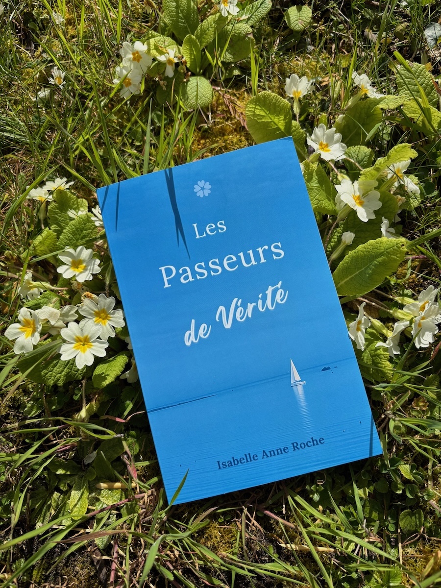Livre Les Passeurs de Vérité posé dans l’herbe parmi des pâquerettes Livre Les Passeurs de Vérité posé dans l’herbe parmi des pâquerettes